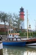 Colorful boats at the port with lighthouse and plants