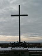 Cross on the War Cemetery in Lerchenberg, Germany, under the clouds