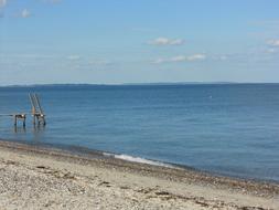 Beautiful sandy coast of the Baltic Sea in Denmark, under the blue sky with clouds