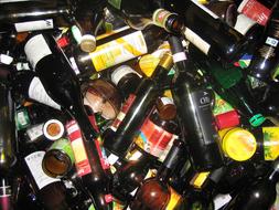 Pile of the shiny, colorful glass bottles with stickers