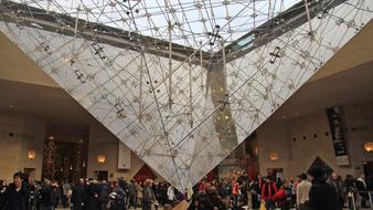 tourists under the pyramid of the louvre