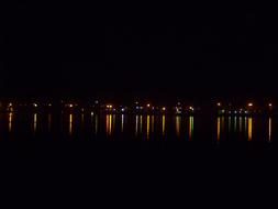 Colorful lights of the buildings, with reflections in the water, at the night