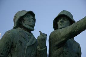 Sculptures of the fishermen in the downtown, under the blue sky