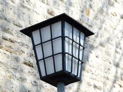 street lamp near white stone wall