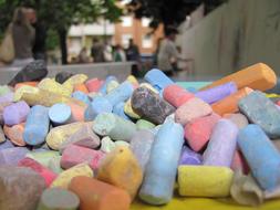 Close-up of the pile of sticks of colorful blackboard chalks, near the building