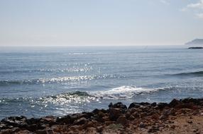 Beautiful beach of the sea with waves, in sunlight