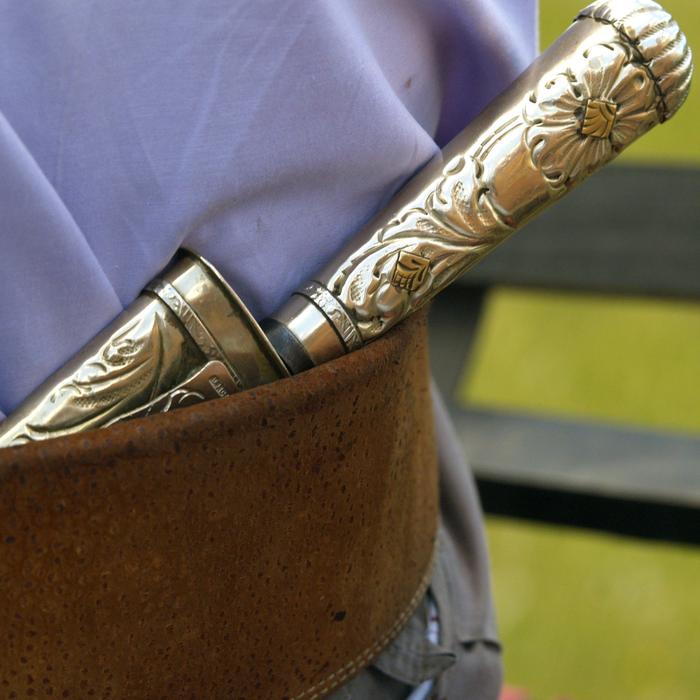 Close-up of the beautiful, patterned, gold knife on the belt of Gaucho