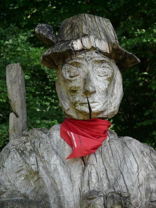 wooden sculpture of a hunter with a red scarf