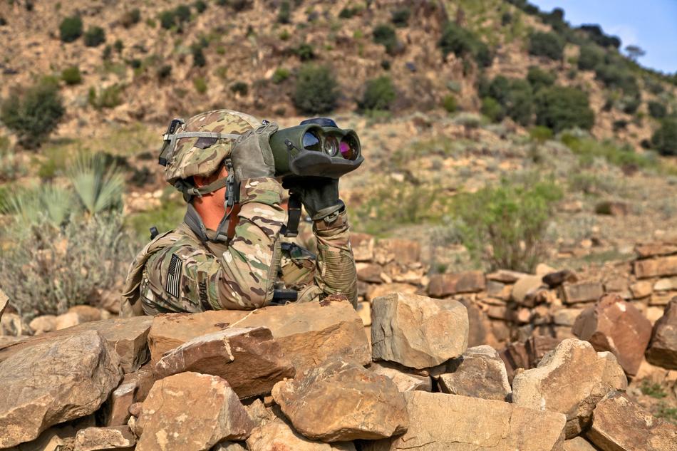 Reconnoiter with the spyglass, behind the rocks, with the green plants