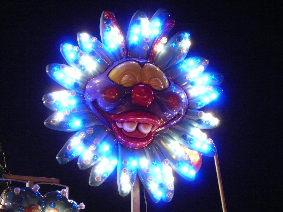 Colorful clown face with neon lights, on the folk festival