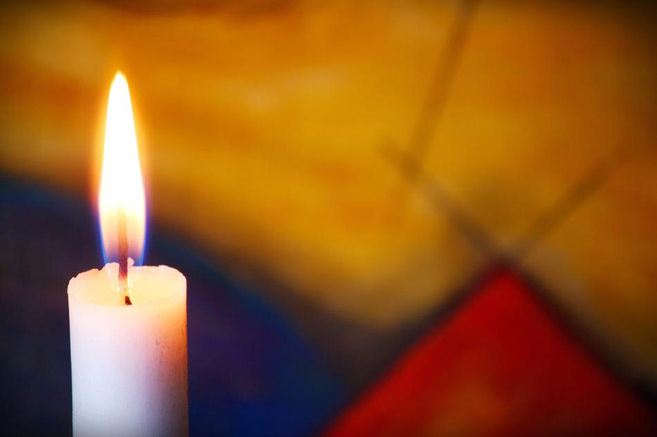 white candle burns at blur background