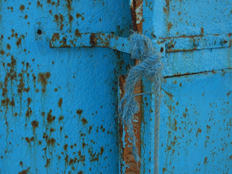 Close-up of a blue rope on the blue steel doors