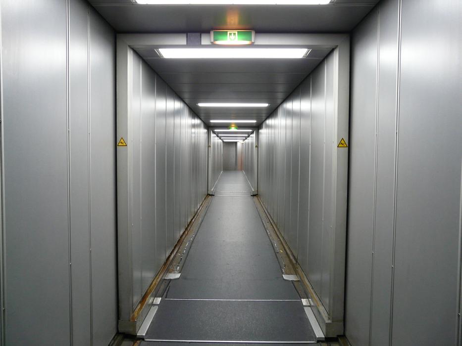 Corridor of the passenger boarding bridge with lights, leading to the aircraft
