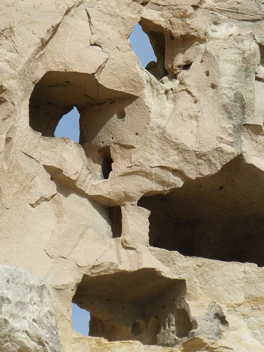 Close-up of the stone construction, with the holes, in sunlight, at blue sky on background