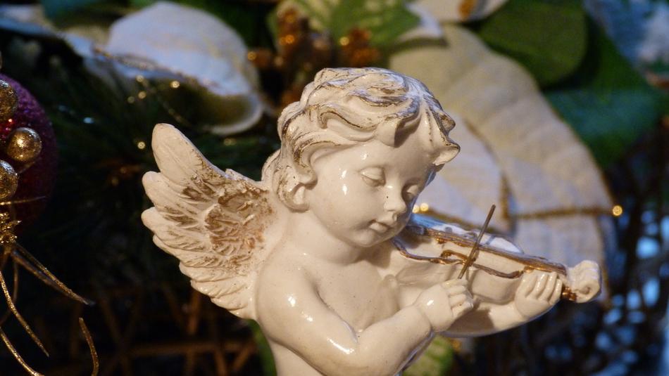 figurine angel with violin on blurred background
