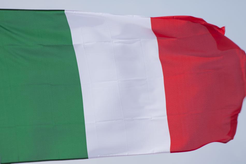 Close-up of the green, white and red flag of Italy, at background with the cloudy sky