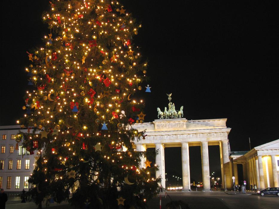 Beautiful Brandenburg Gate and green Christmas tree with colorful decorations, in Berlin, Germany, at night