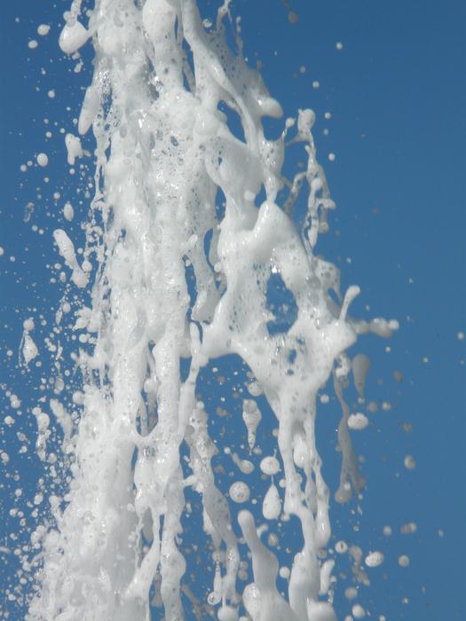 white foam fountain on blue sky background