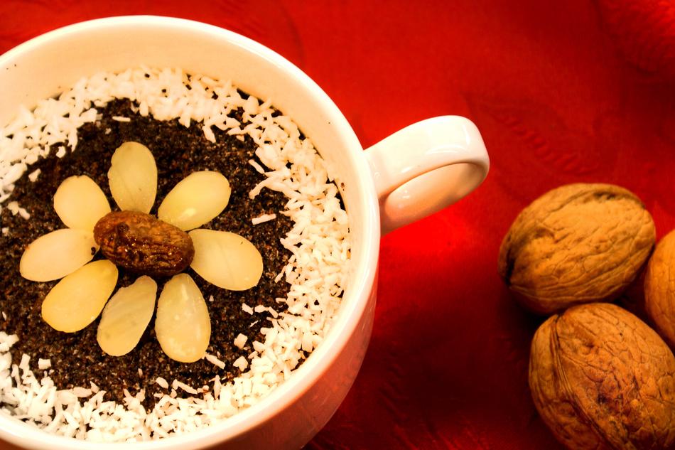 Beautiful Makówki in cup, near the walnuts, on the red surface
