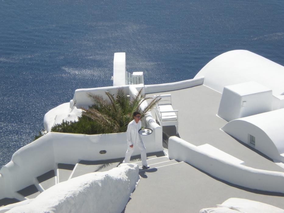 man in white clothes on the stairs on a greek island