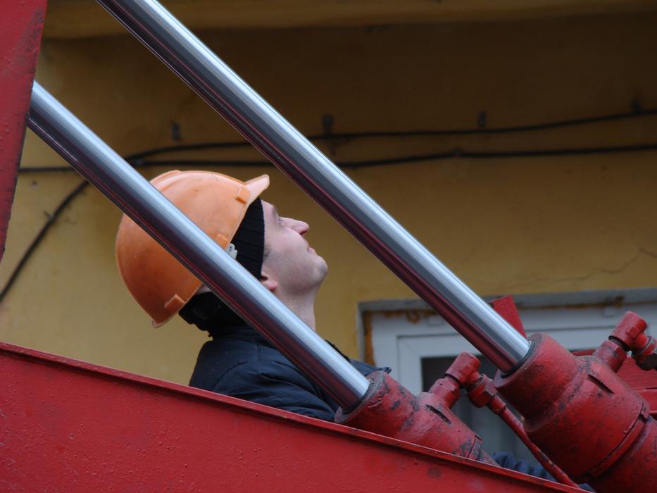 Man in helmet sawing trees with the machine