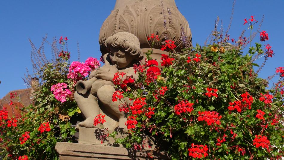plants with red flowers near the sculpture