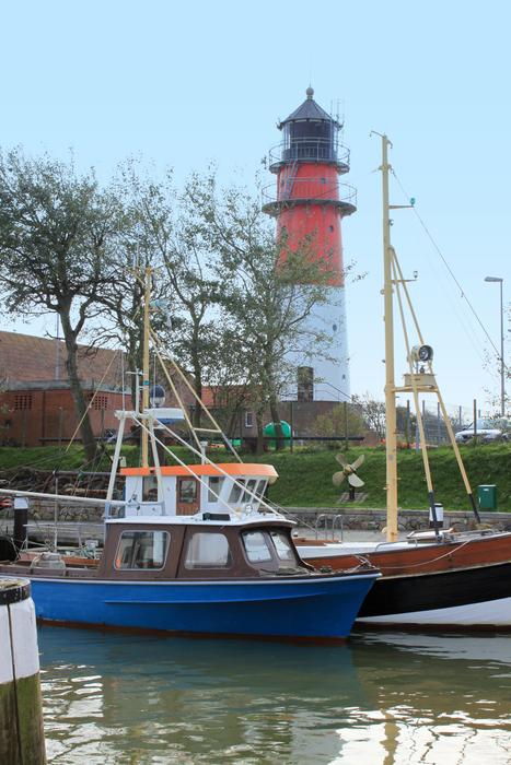 Colorful boats at the port with lighthouse and plants