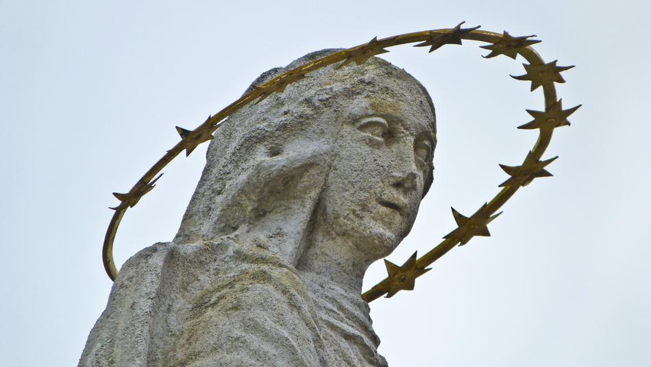statue with a halo of stars on the background of the sky