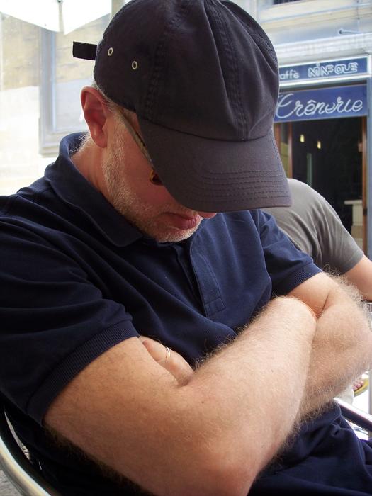 Man in black cap, sleeping while sitting