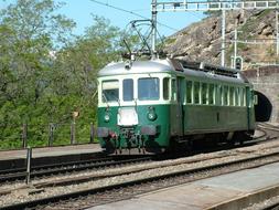 green tram on the railroad