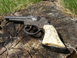 old pistol on a tree stump close up