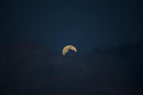 Beautiful Moon behind the dark clouds, at the night