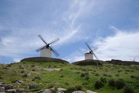 two windmills on a green hill