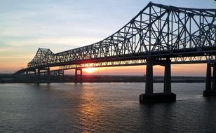 metal bridge over the river during sunset