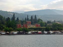 Beautiful shore of the Garda Lake in Malcesine, Italy, with plants, buildings and mountains