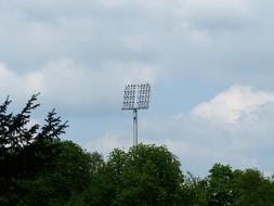 green trees, spotlight, white clouds