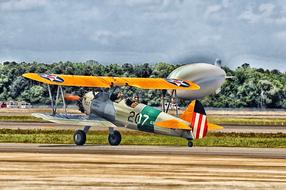 Colorful airplane at the airport of Jacksonville in Florida, USA, near the green trees