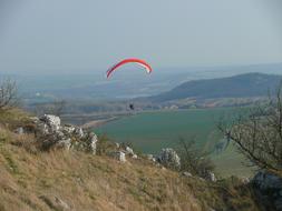 Paraglider flying above the colorful and beautiful Palava mountains in Czech Republic