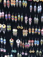 Colorful and beautiful earrings with patterns, on the black stand