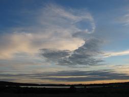 Beautiful and colorful evening sky with clouds, above the landscape