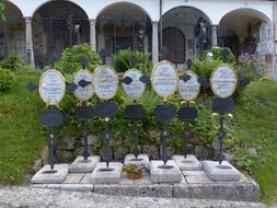 Graves with signs, among the plants, at the Cemetery of the Monastery St Peter in Salzburg, Austria