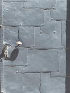 Close-up of the metal door with the handle, in sunlight