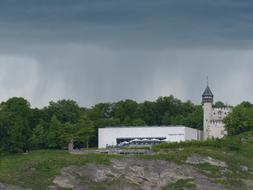 Museum of Modern among the green trees, in MÃ¶nchberg, Austria, under the clouds