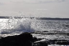 Splash of Water on rocky coast at dusk