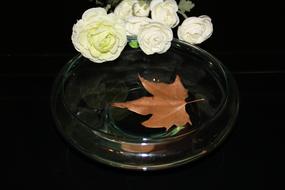 bouquet of white roses and autumn maple leaf in water