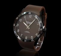 Close-up of the shiny, brown "Omax" male watch, at black background