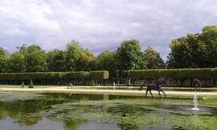 people in the park near the lake with fountains