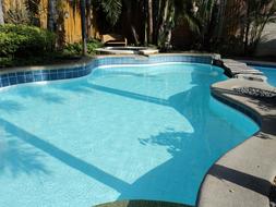 Beautiful, turquoise pool in sunlight, among the colorful plants