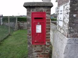 red mailbox in a brick column