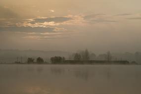 Beautiful, foggy pond among the trees, at colorful and beautiful sunrise